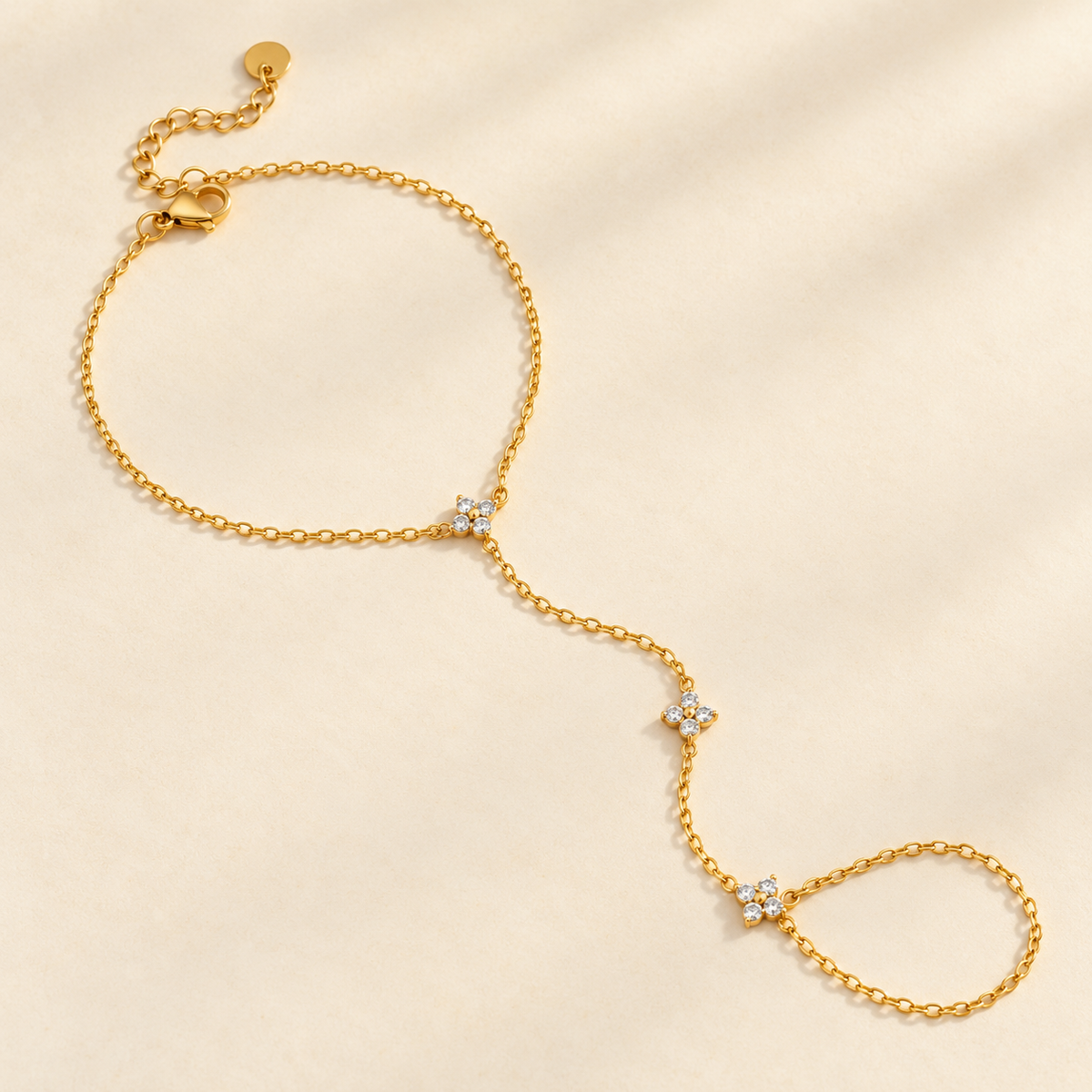 Bracelet de main KINÉ en acier inoxydable doré, chaîne de doigt et trois motifs à quatre strass