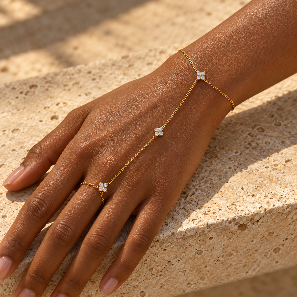Bracelet de main KINÉ doré porté sur peau foncée, du poignet au doigt