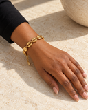 Bracelet CORIS à cauris dorés porté au poignet avec une manche noire