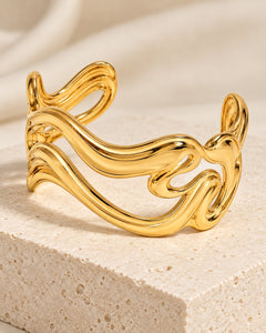Bracelet manchette Vague en acier inoxydable, coloris doré, aux courbes ondulées et ajourées.