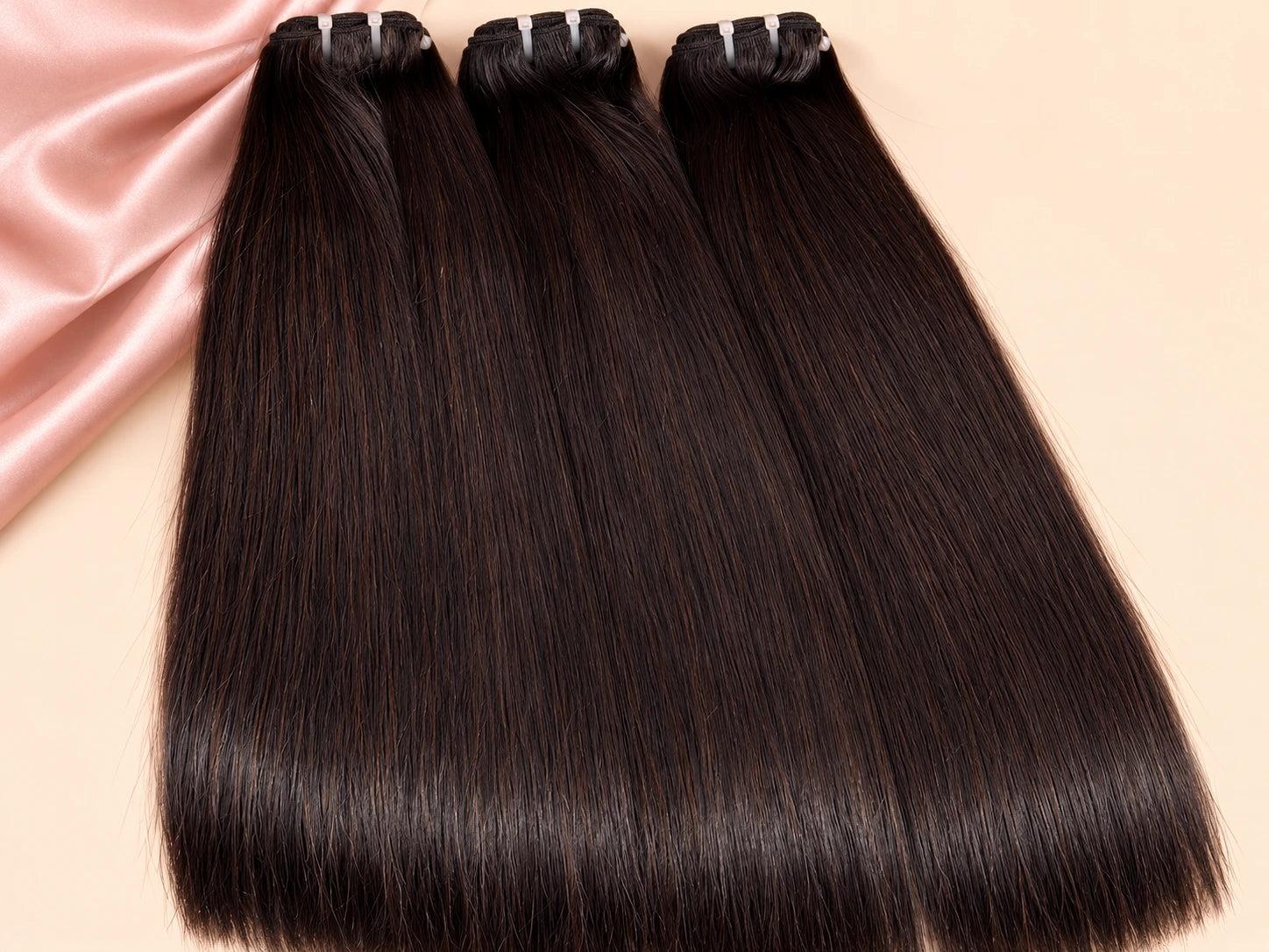 Trois bundles de cheveux noirs avec leurs bandes de tissage